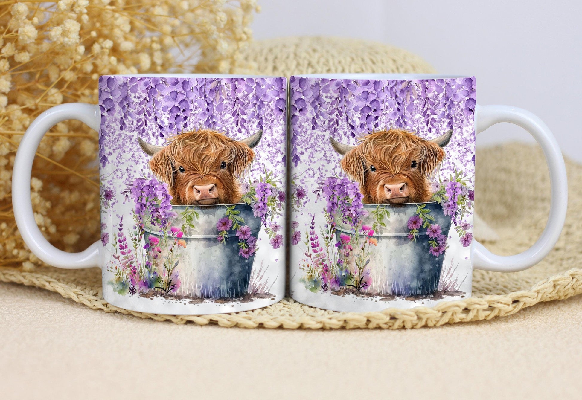 Two white ceramic mugs featuring a highland cow mug design with purple flowers and a rustic bucket