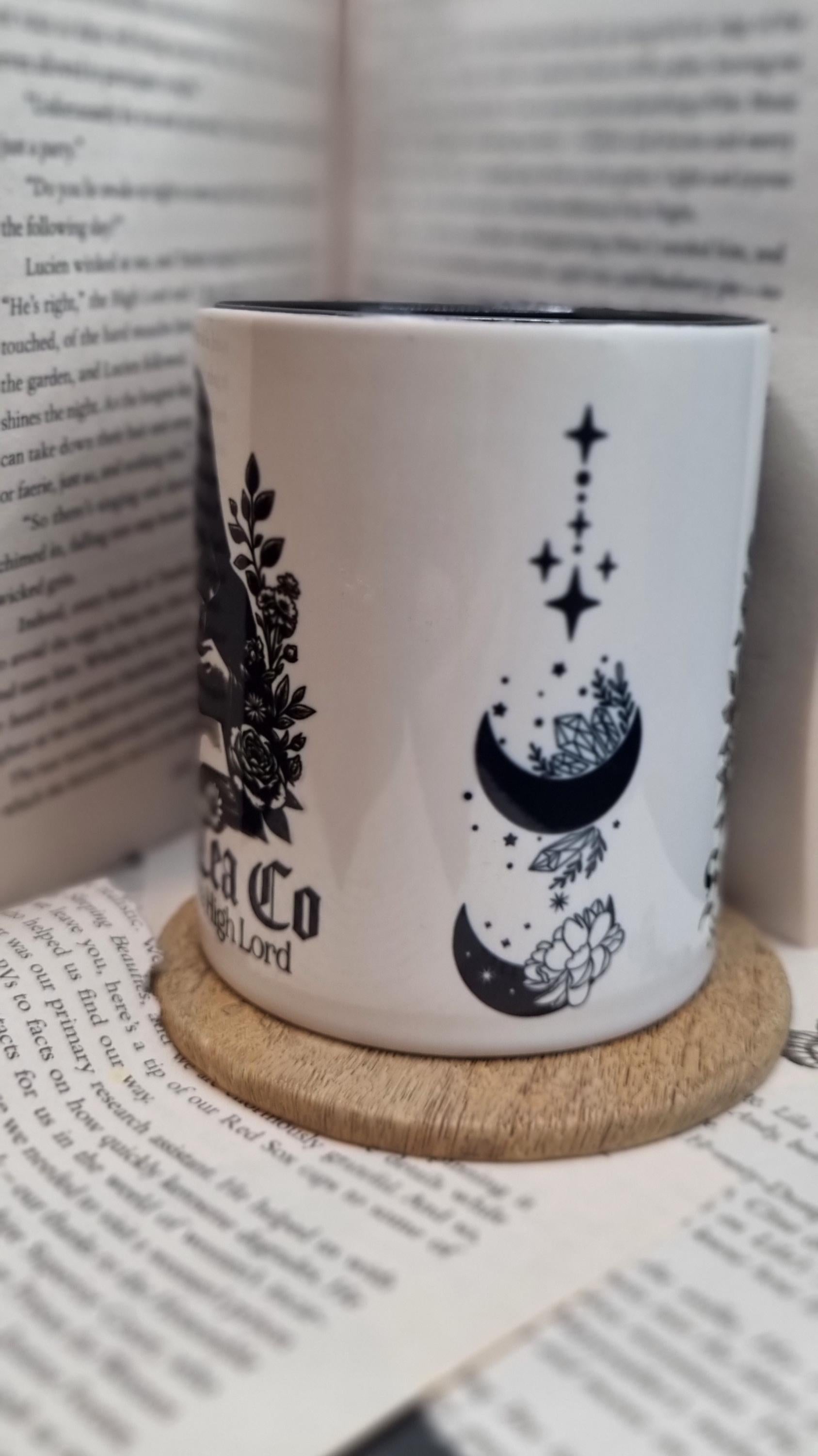 White ceramic Acotar themed mug gift with black moon and floral designs on wooden coaster