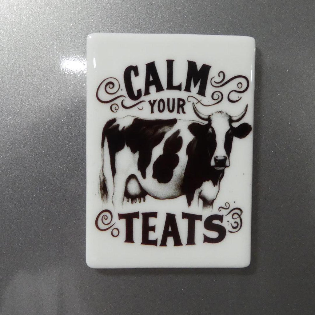 Calm your teats novelty magnet with black and white cow design on white rectangular background