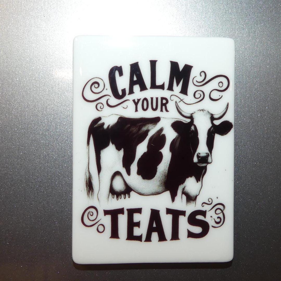 Calm your teats novelty magnet featuring a black and white cow illustration 