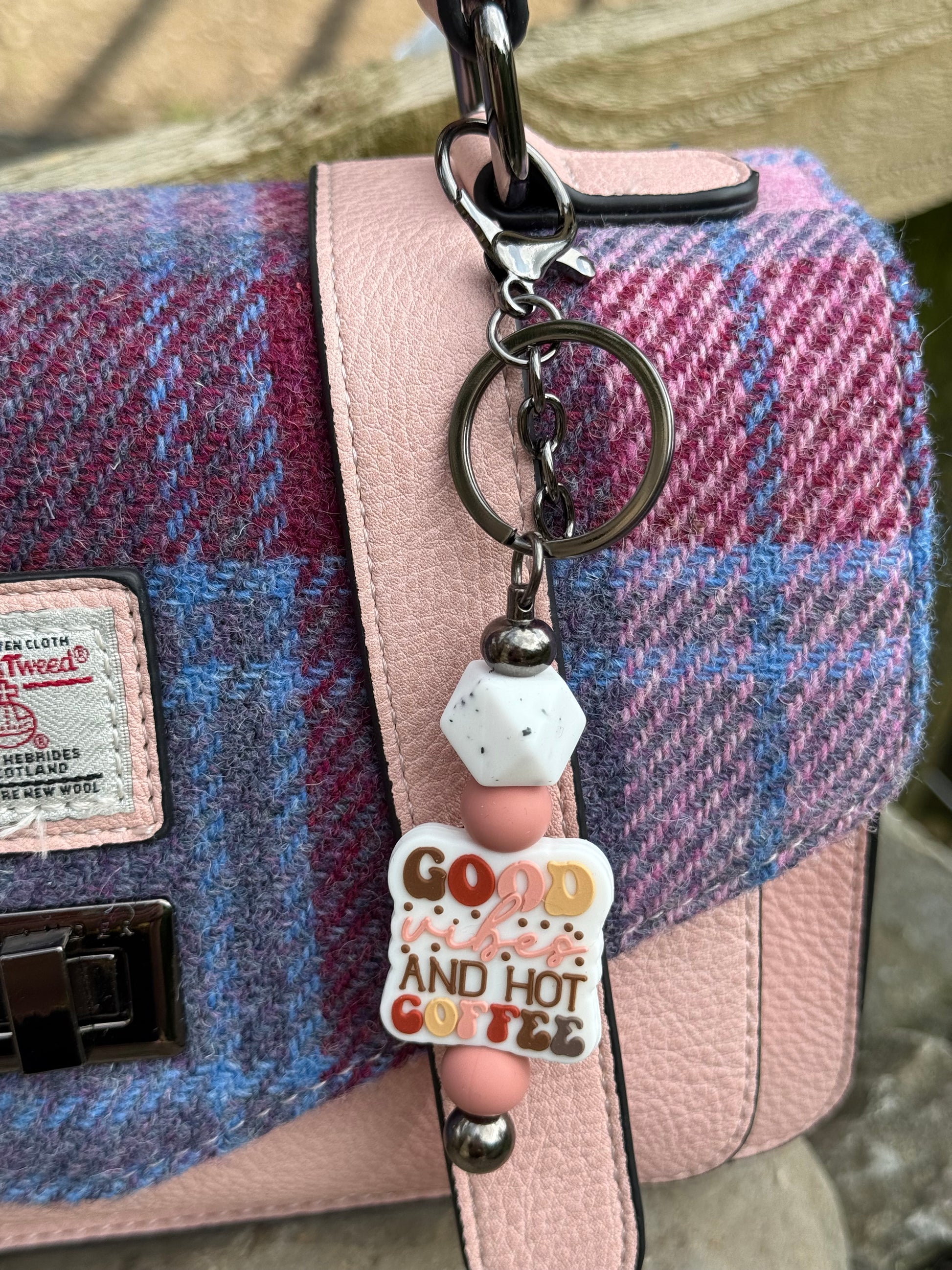Cute coffee lover keyring with colourful beads and a pendant reading good and hot coffee attached to blue and pink handbag