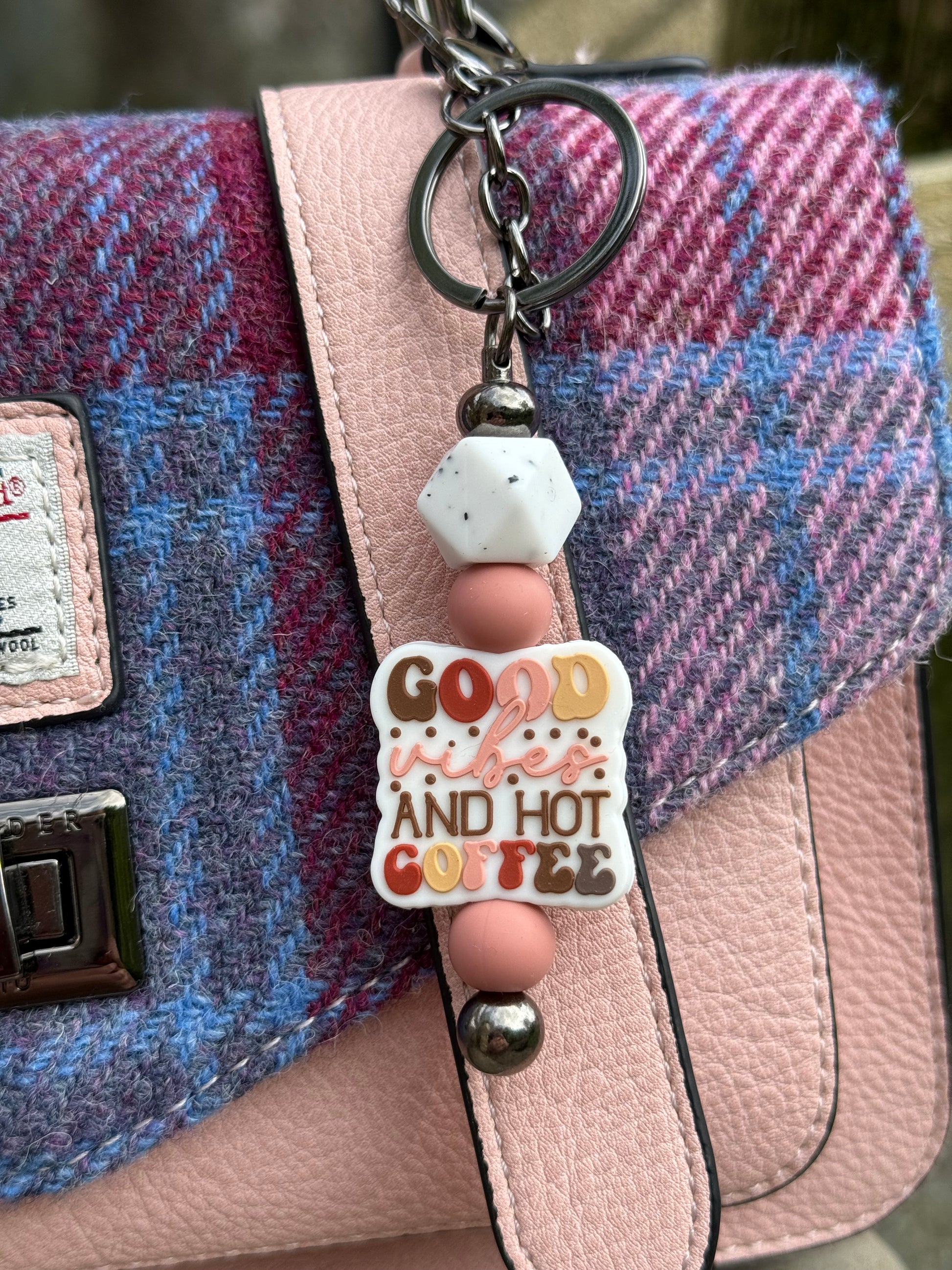 Cute coffee lover keyring with colourful 'Good vibes and hot coffee' charm hanging on pink and blue textured handbag