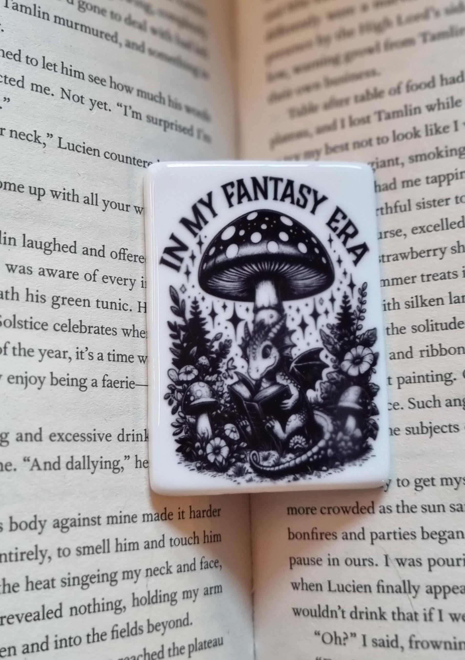 Black and white fantasy dragon fridge magnet with mushroom and forest design on open book background