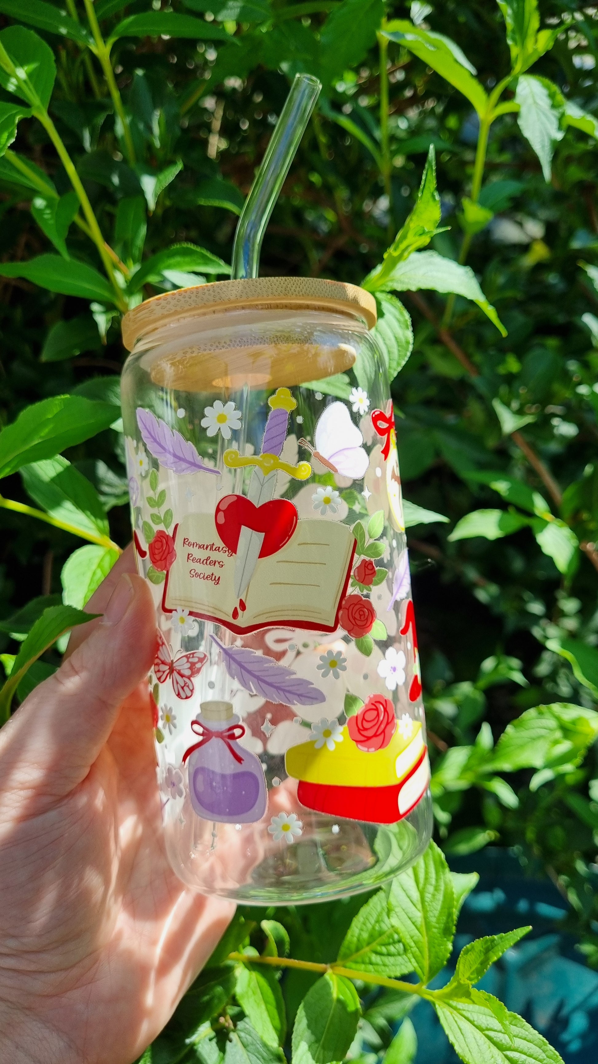 Fantasy romance bookish tumbler with straw featuring hearts, flowers, book, and butterfly design