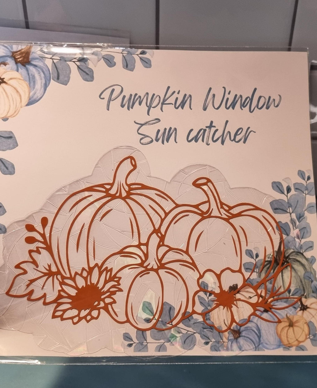 Cute pumpkin sun catcher with three pumpkins and flowers on a window decoration 