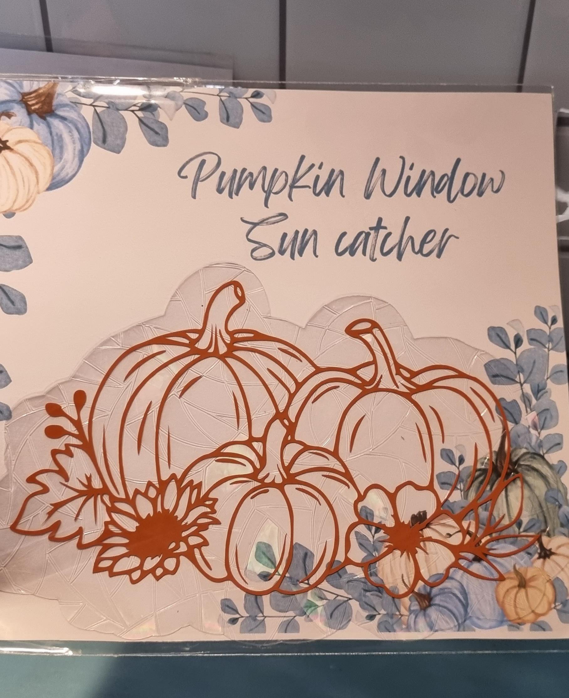 Cute pumpkin sun catcher with three pumpkins and flowers on a window decoration 