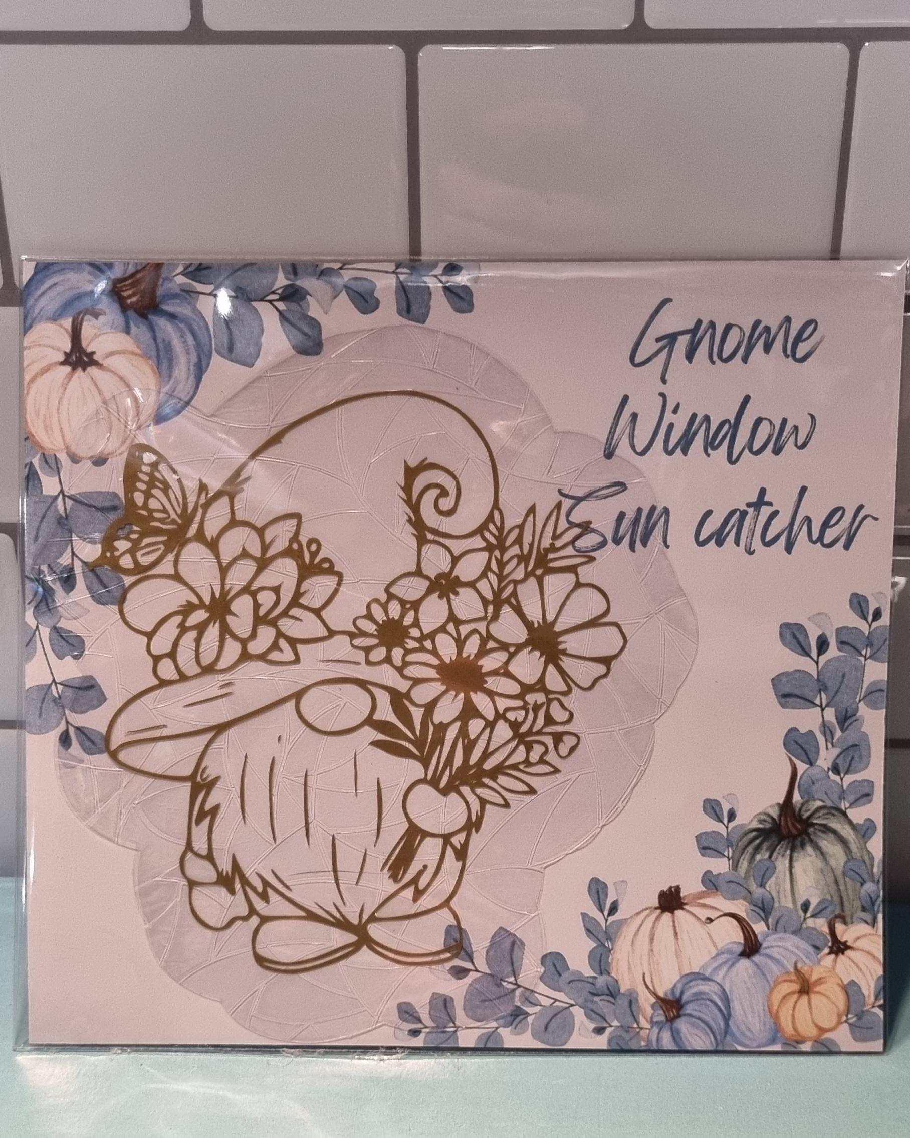 Gold gonk suncatcher featuring a gnome holding flowers with butterfly detail for window decoration