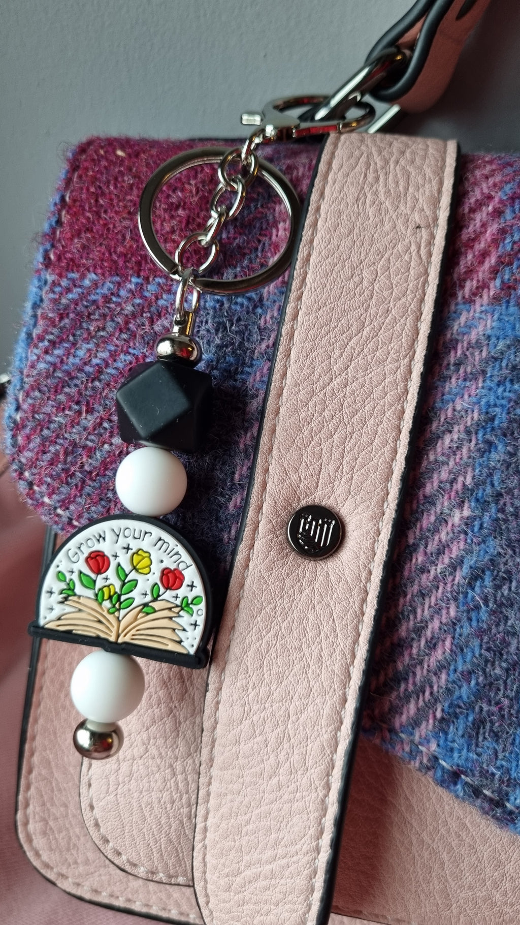 Sublimely Special grow your mind keychain with colourful flower design attached to pink leather bag