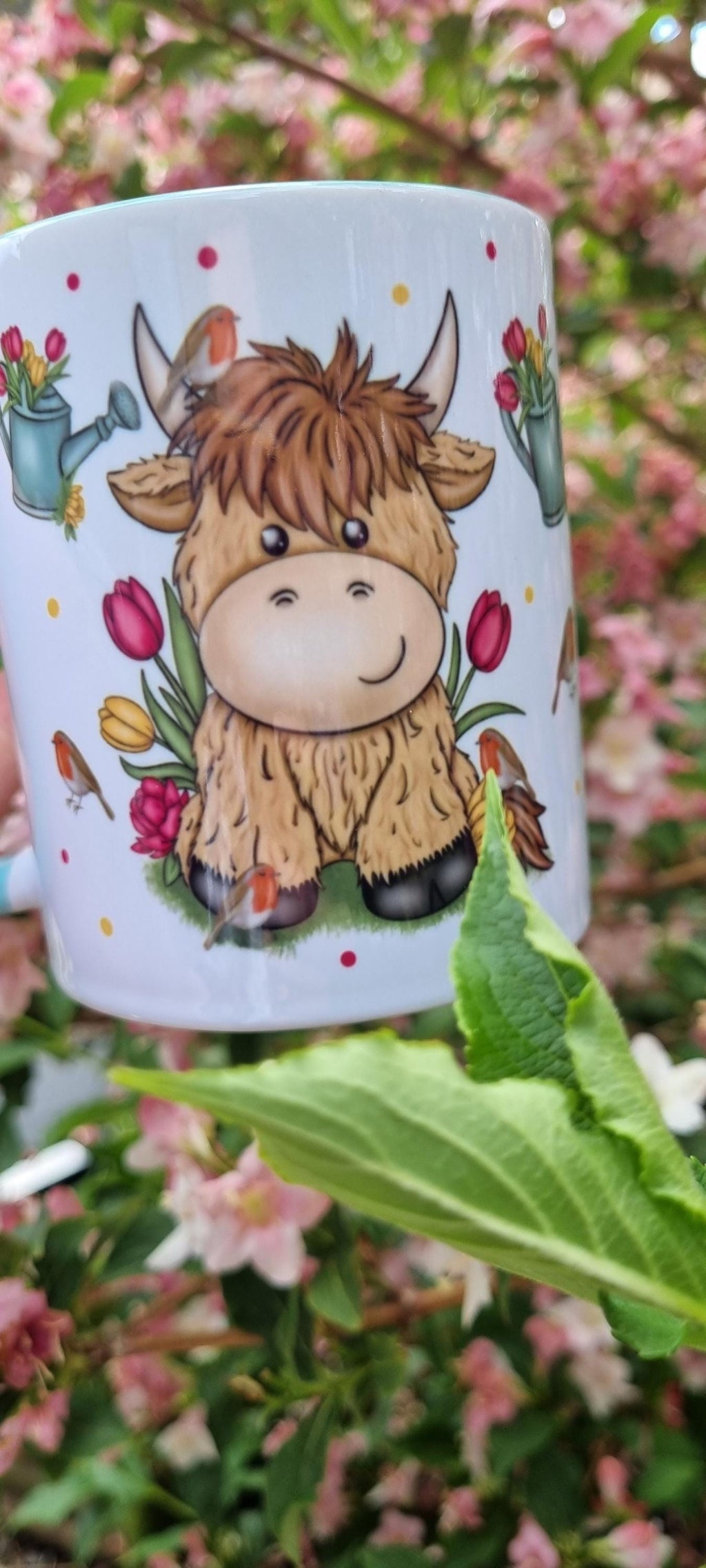 Ceramic mug featuring a cute cartoon highland cow surrounded by flowers, perfect highland cow gift for animal lovers