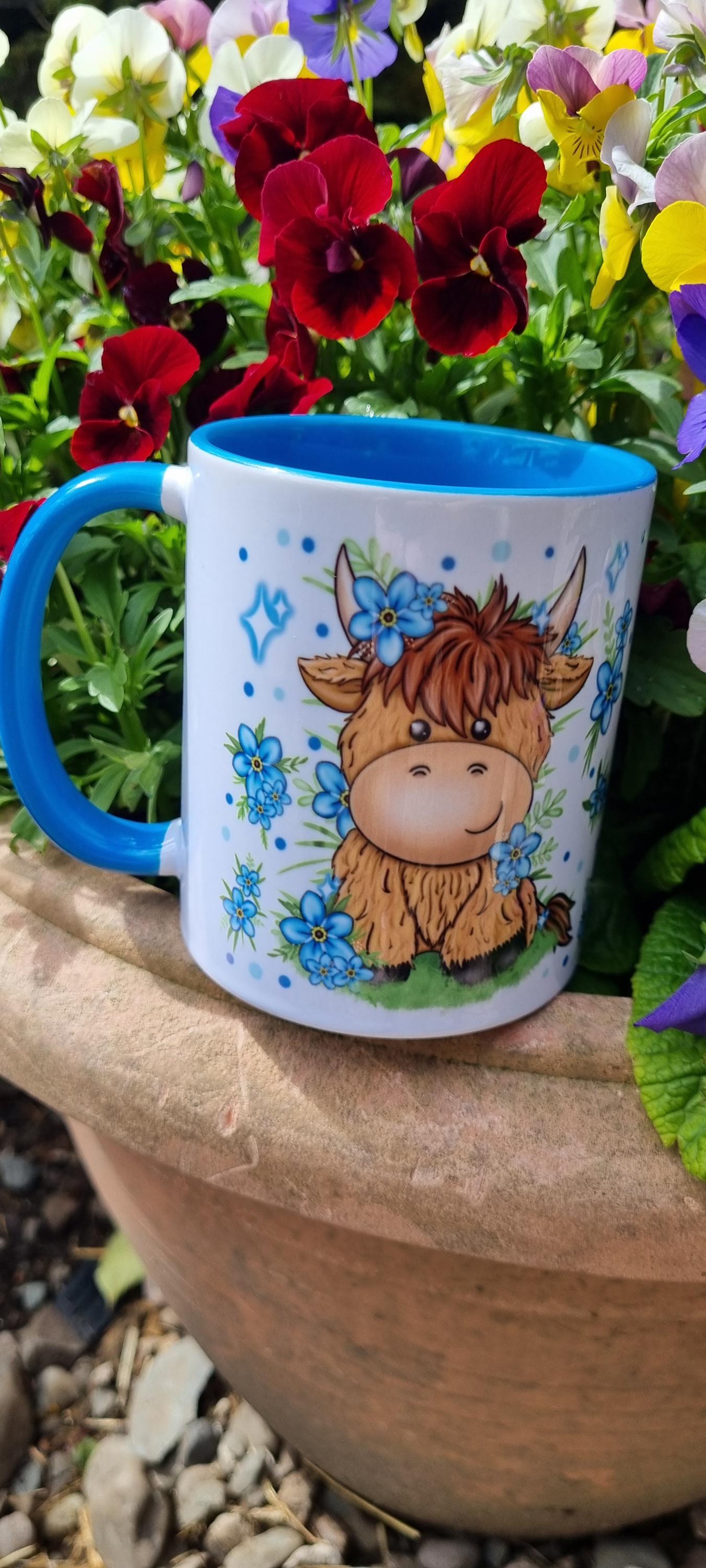 Cute blue-handled mug featuring a highland cow design surrounded by flowers highland cow gift for animal lovers