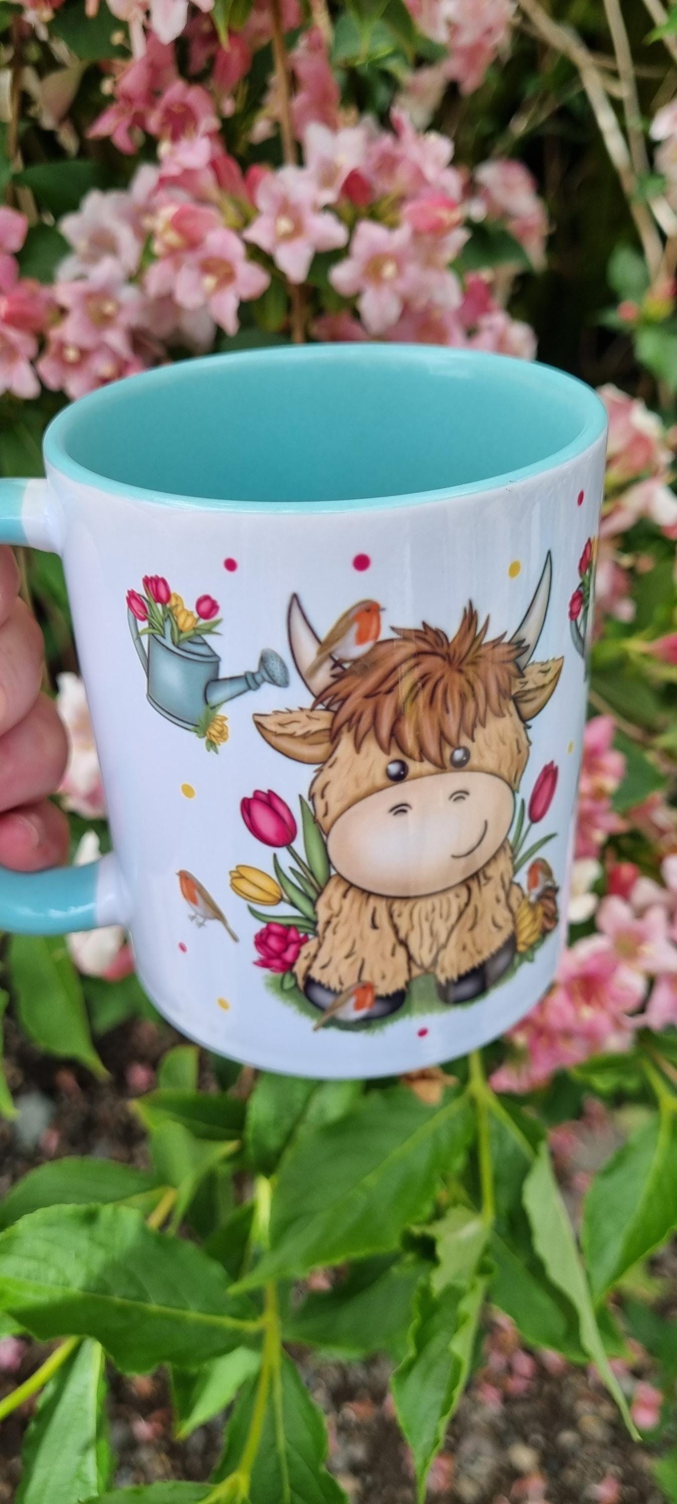 White mug with blue interior featuring cute highland cow illustration and flowers, perfect highland cow gift for animal lovers