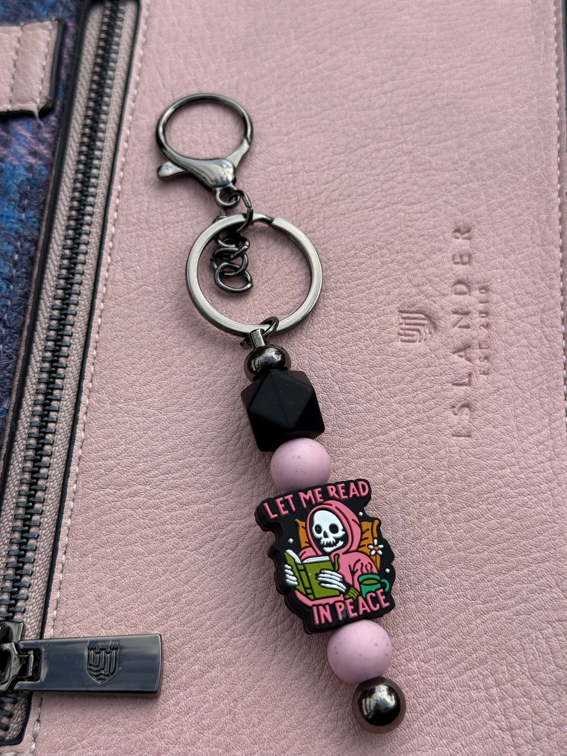Sublimely Special let me read in peace keyring featuring a skull reading a book with pink and black beads