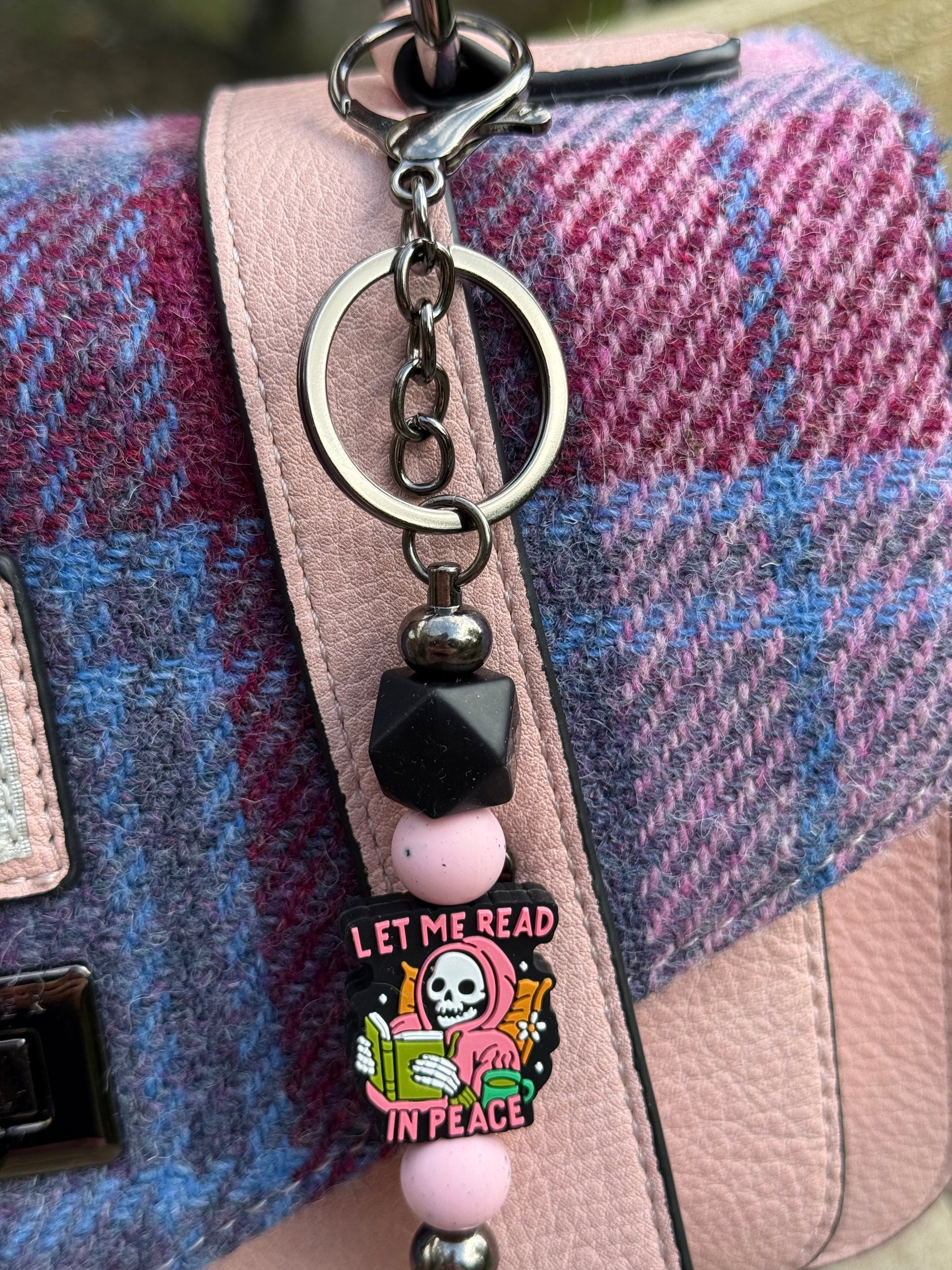 Sublimely Special let me read in peace keyring featuring a skeleton reading a book with beads on a pink and black chain