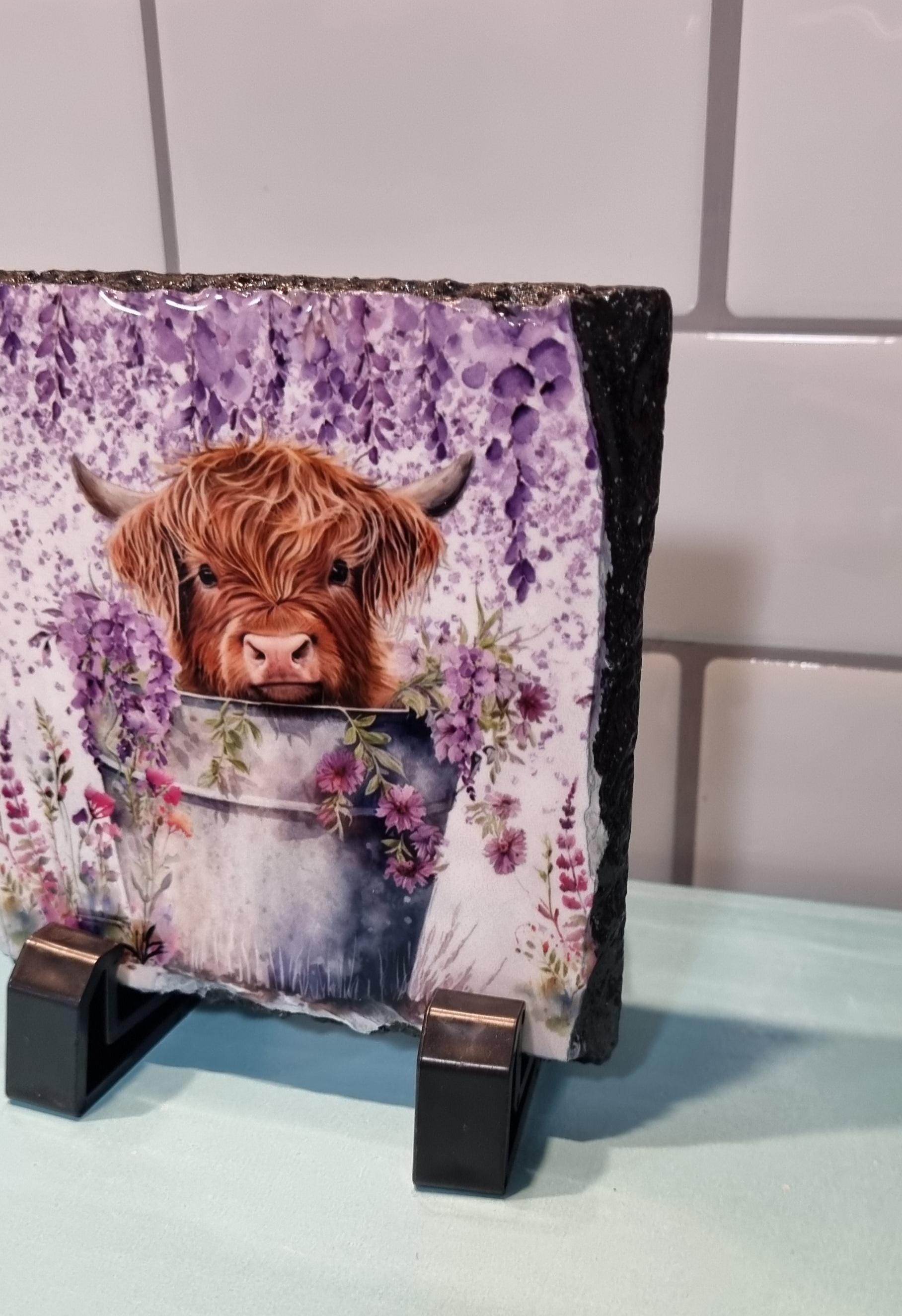 Lilac highland cow coaster featuring a cute highland cow in a bucket with purple flowers