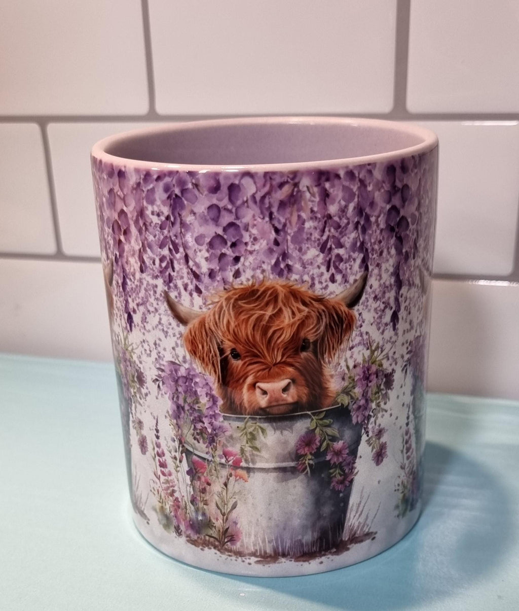 Lilac highland cow mug featuring a cute highland calf in a bucket surrounded by lilac flowers