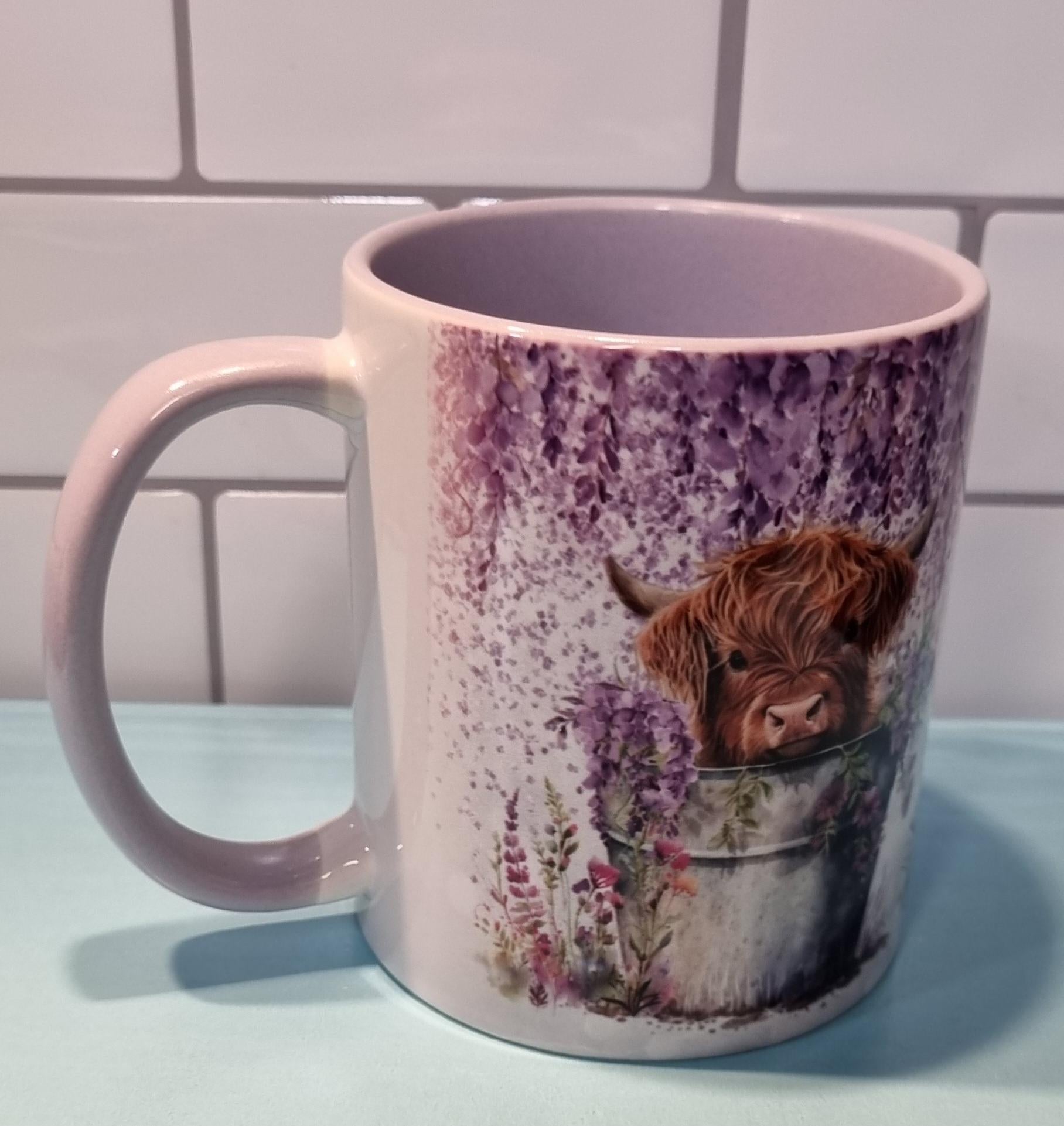 Lilac highland cow mug featuring a cute highland cow in a bucket with lilac flowers design