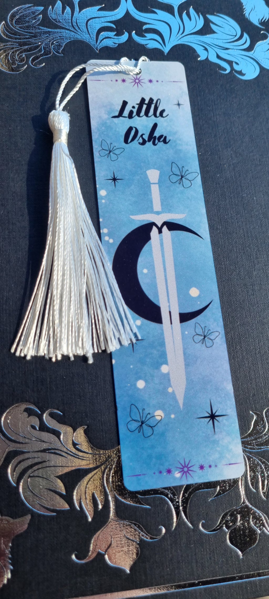 Little Osha book gift featuring a blue bookmark with a sword and crescent moon design by Sublimely Special