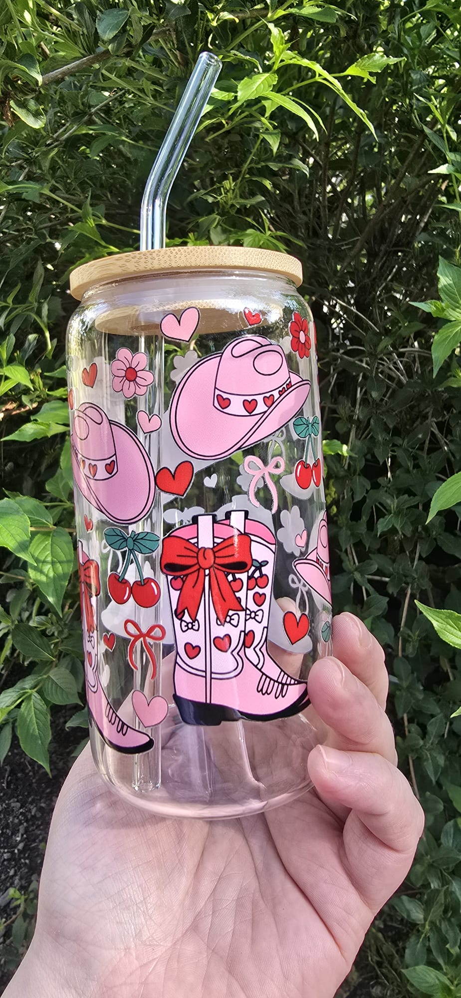 Pink cowgirl glass tumbler with heart and floral designs and a bamboo lid with glass straw