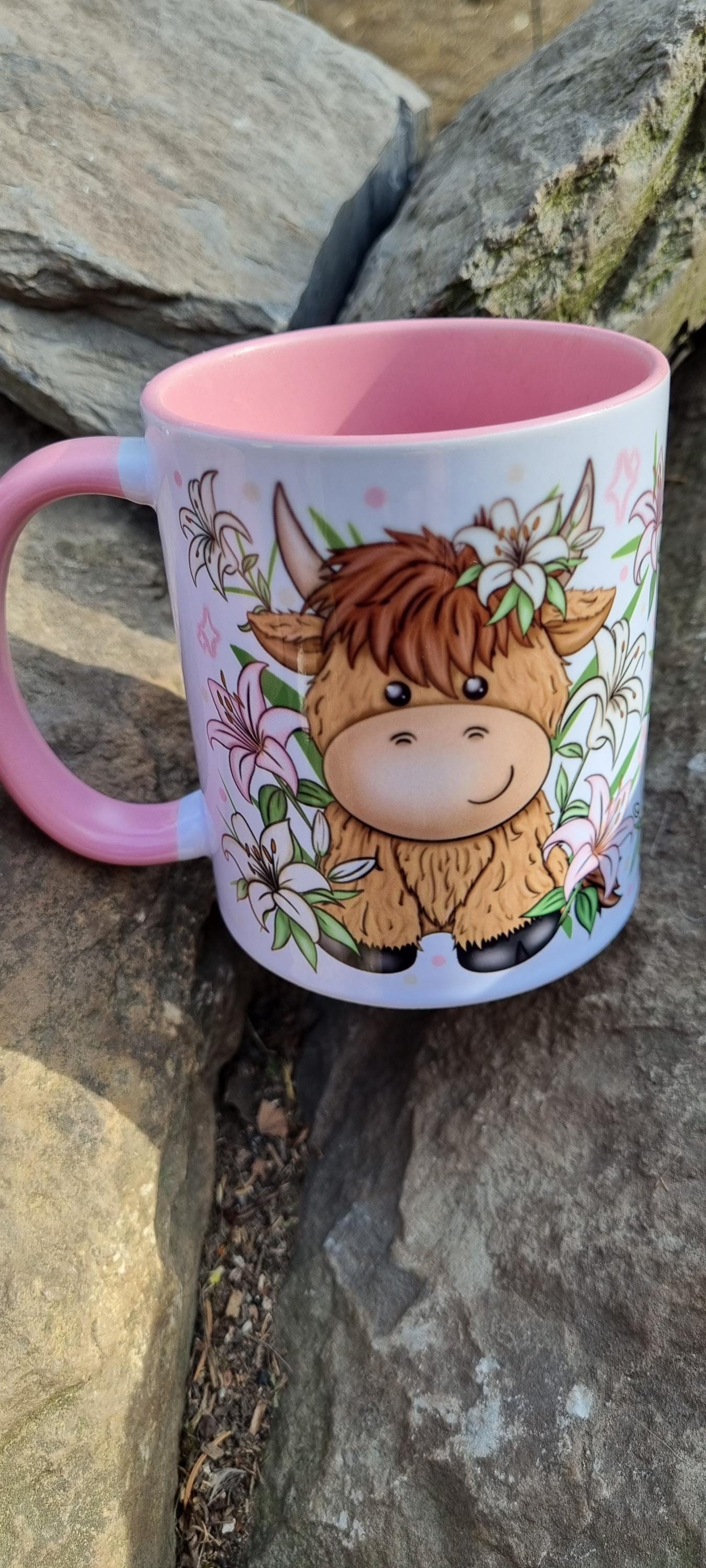 Pink highland cow mug with cute cartoon cow and floral design on white background