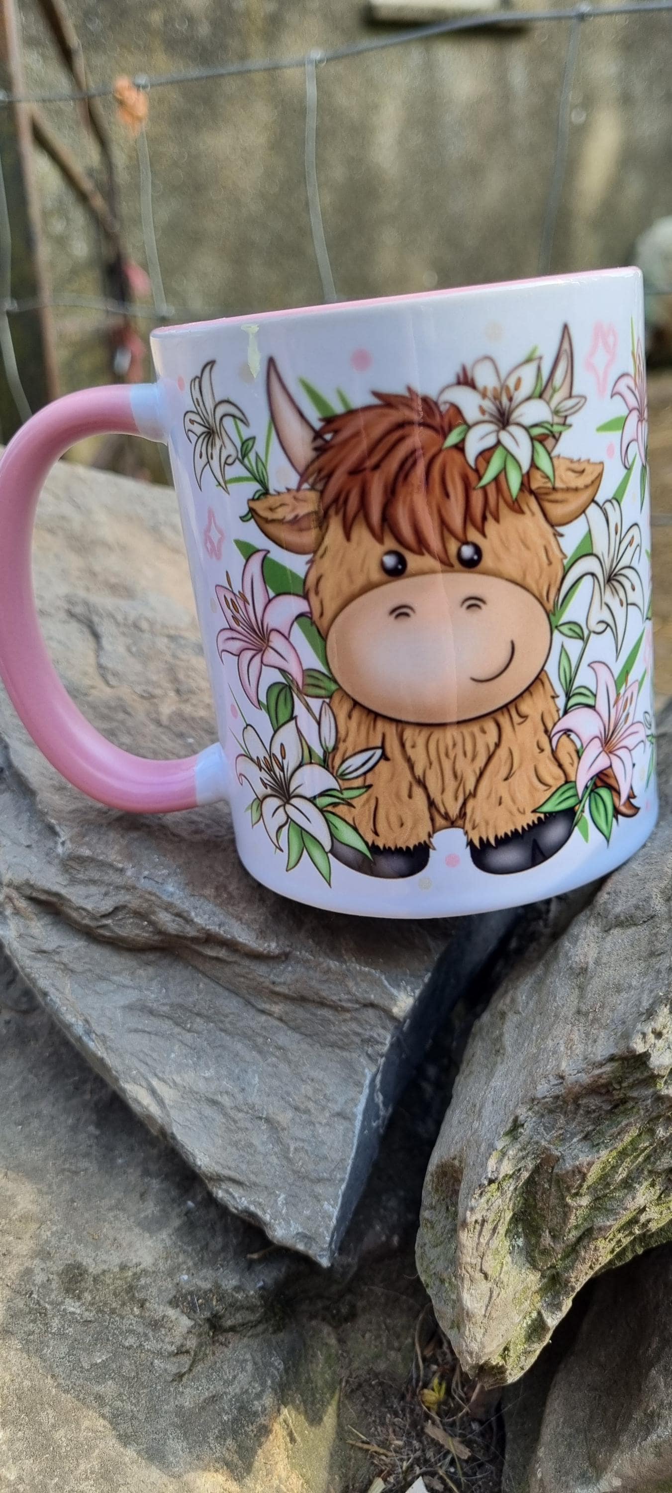 Pink highland cow mug with cute cartoon cow and floral design on white ceramic