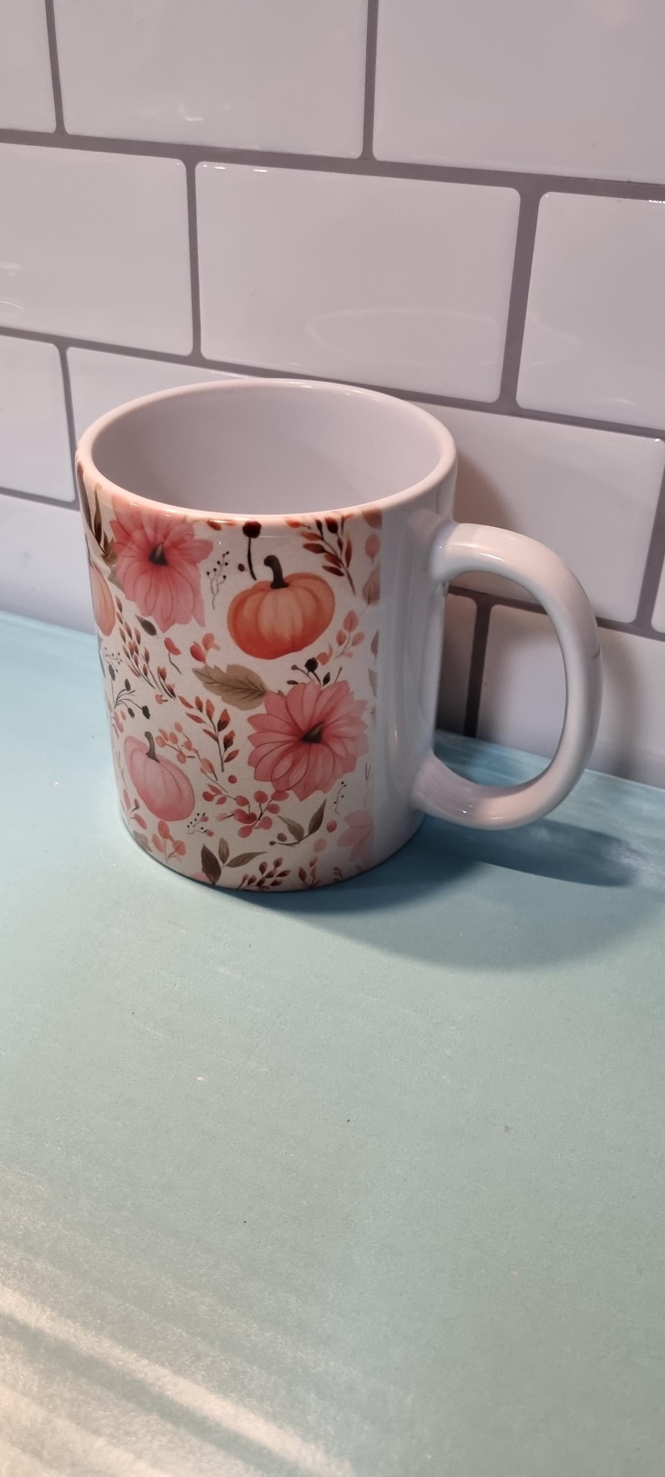 White ceramic pumpkin and flowers mug with orange pumpkin and pink floral design