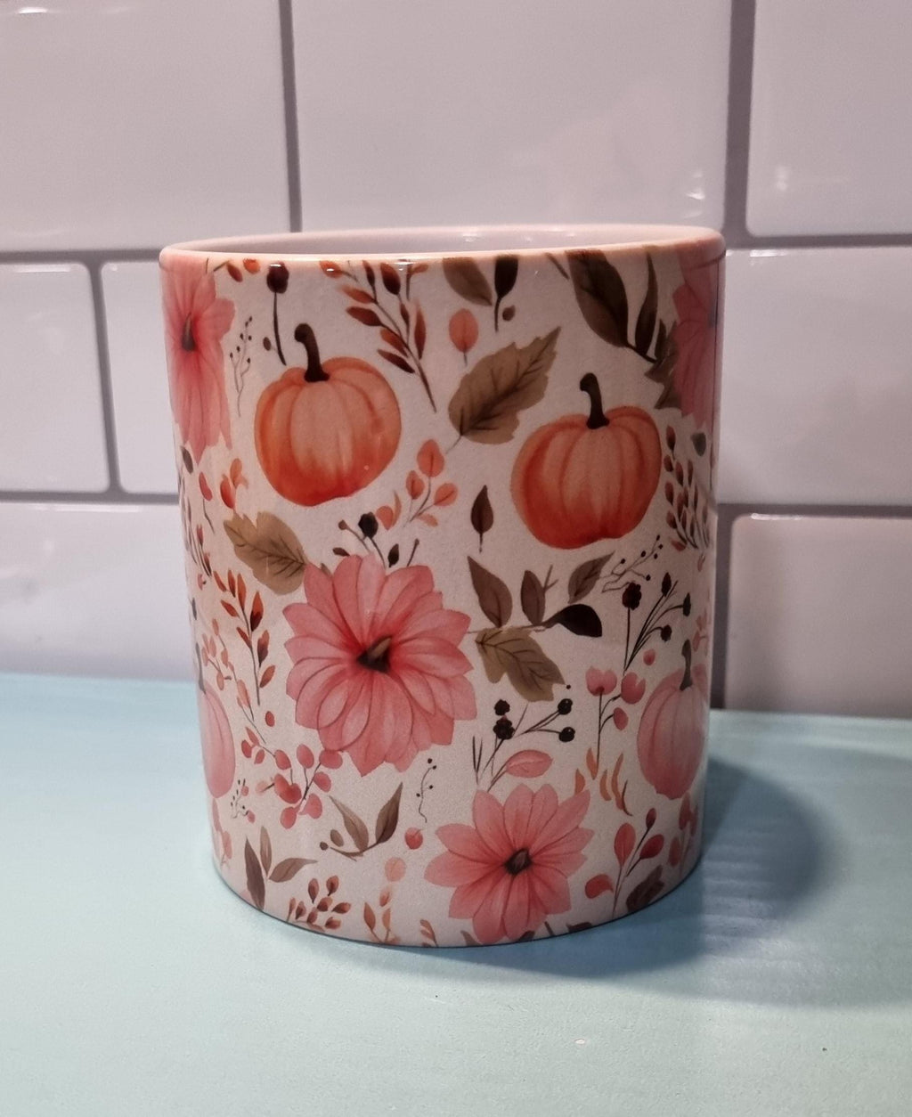 Ceramic pumpkin and flowers mug with autumn design featuring orange pumpkins and pink flowers
