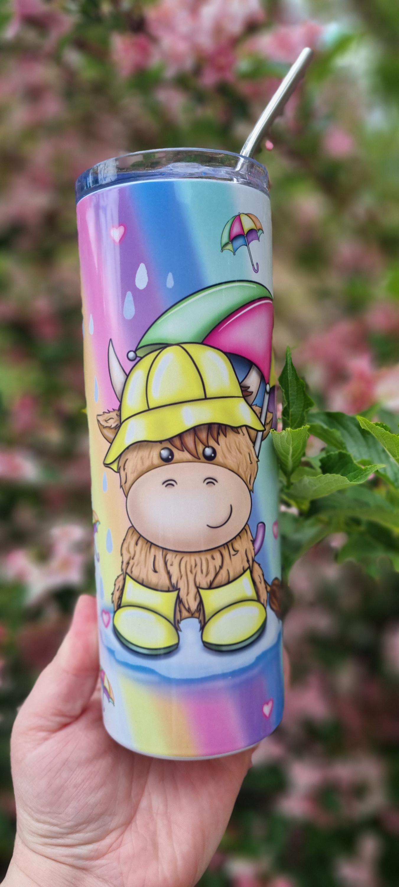 Rainbow highland cow tumbler with cute cartoon cow wearing yellow rain boots and hat on pastel rainbow background