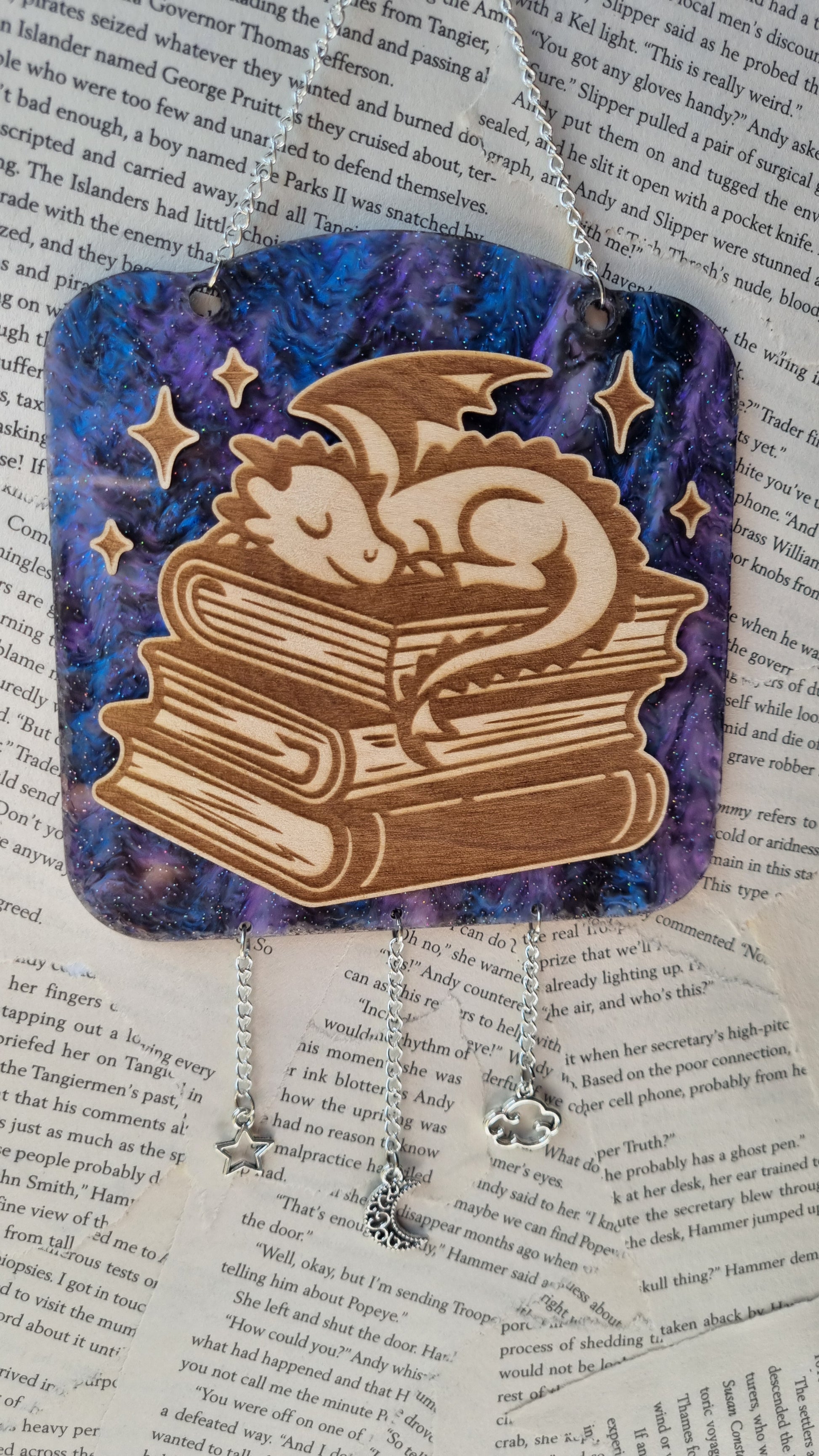 Sleepy dragon library ornament featuring a curled dragon resting on stacked books with star decorations