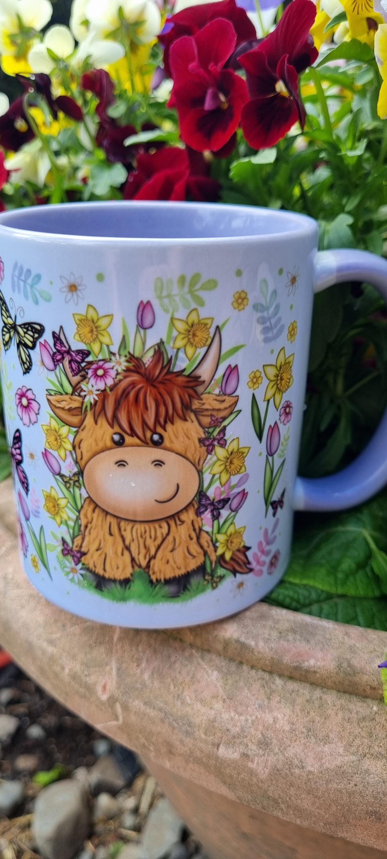 Spring cow coffee cup with cute cow and colourful spring flowers design on lilac background