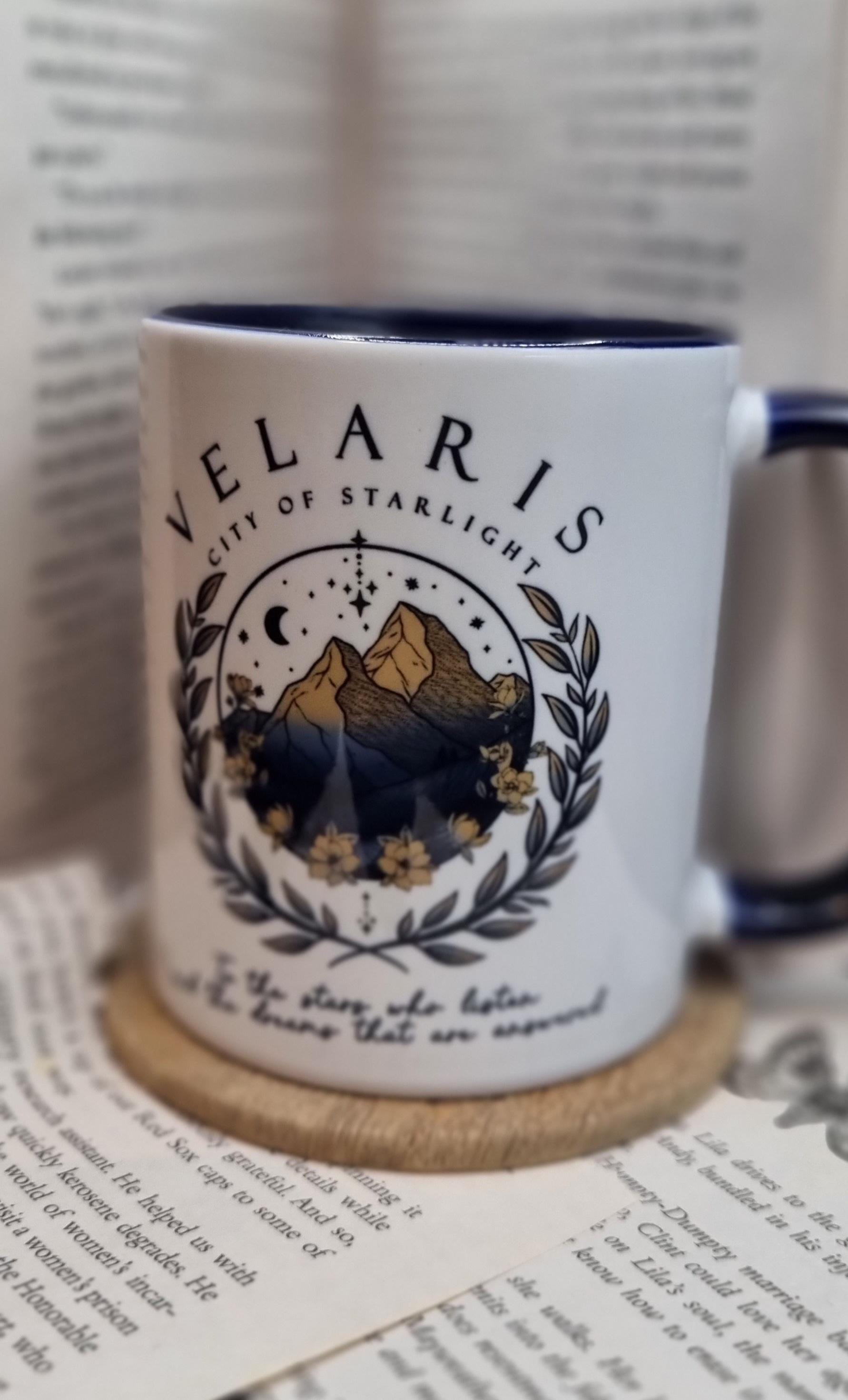 White Velaris City of Starlight mug with mountain and floral design on wooden coaster