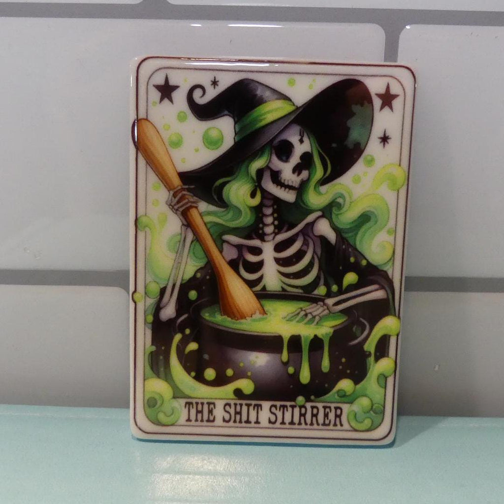 Witchy tarot fridge magnet featuring a skeleton witch stirring a bubbling green cauldron with text The Shit Stirrer